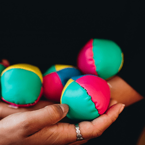 Des balles de jonglage portées par une personne habillée en noir.