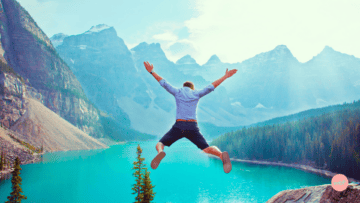 Un homme fait le grand saut au dessus d'un lac.
