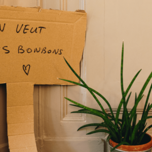 Une pancarte en carton sur laquelle il est écrit : On veut des bonbons.