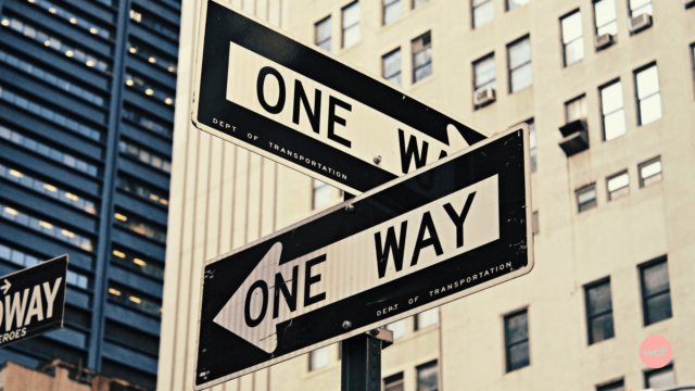 Deux panneaux indiquent des directions opposées.