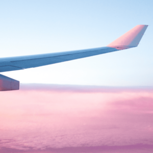 Une aile d'avion au dessus d'un coucher de soleil.