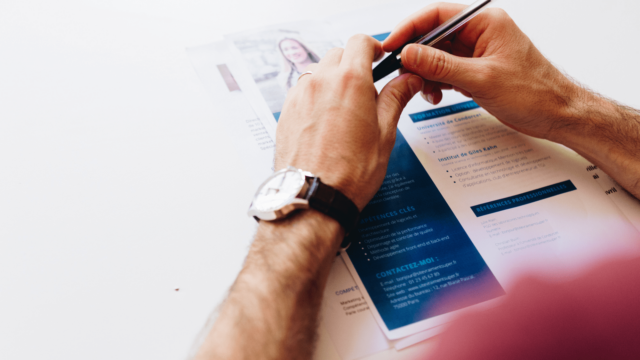 Un homme tient un CV devant lui.