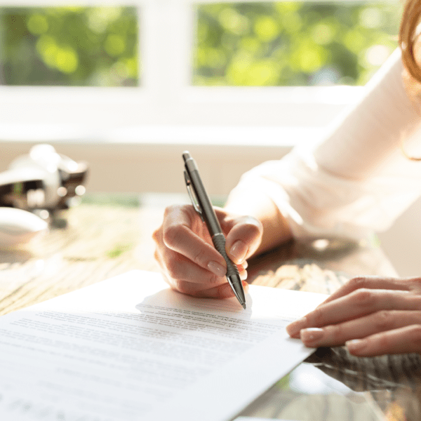 Une femme est en train de signer un contrat.