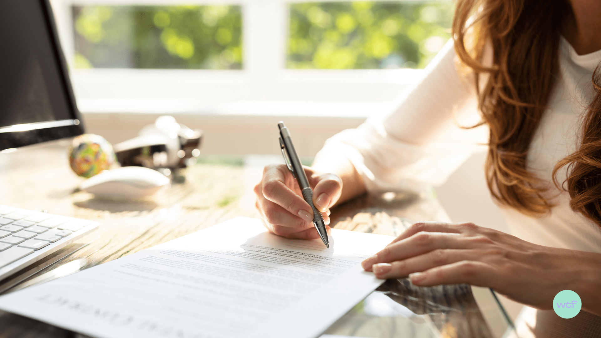 A woman is signing a contract.