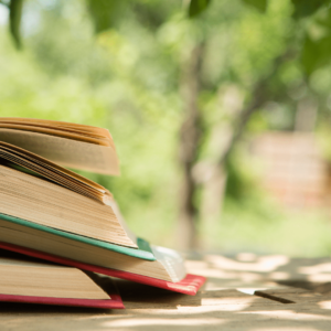 Une pile de livres ouverts sur une table en extérieur.