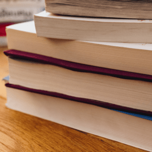 Plusieurs livres sont empilés sur une table.