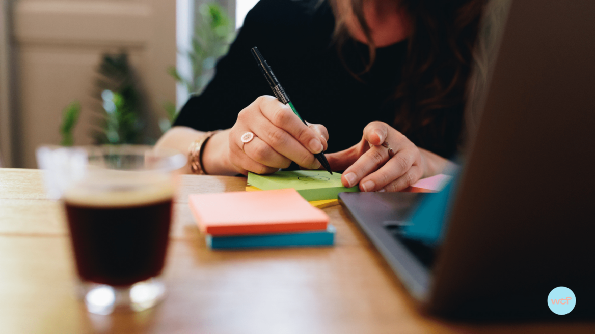 Une collaboratrice qui écrit sur des postit pour illustrer les moments de convivialité en entreprise.