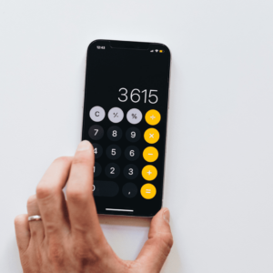 Une calculatrice noire avec des touches jaunes sur un fond blanc.