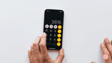 Une calculatrice noire avec des touches jaunes sur un fond blanc.