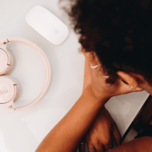 Une femme tient sa tête dans ses mains dans une posture de fatigue ou d'échec.