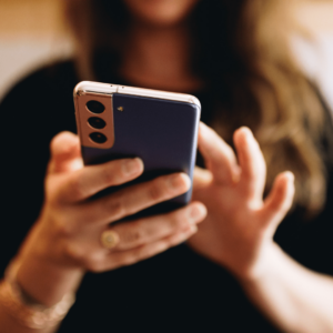 Une femme utilise un téléphone portable, vue de face.