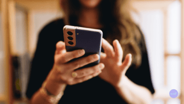 Une femme utilise un téléphone portable, vue de face.