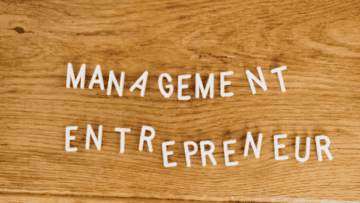 Les mots Management et Entrepreneur sont écris sur une table en bois.