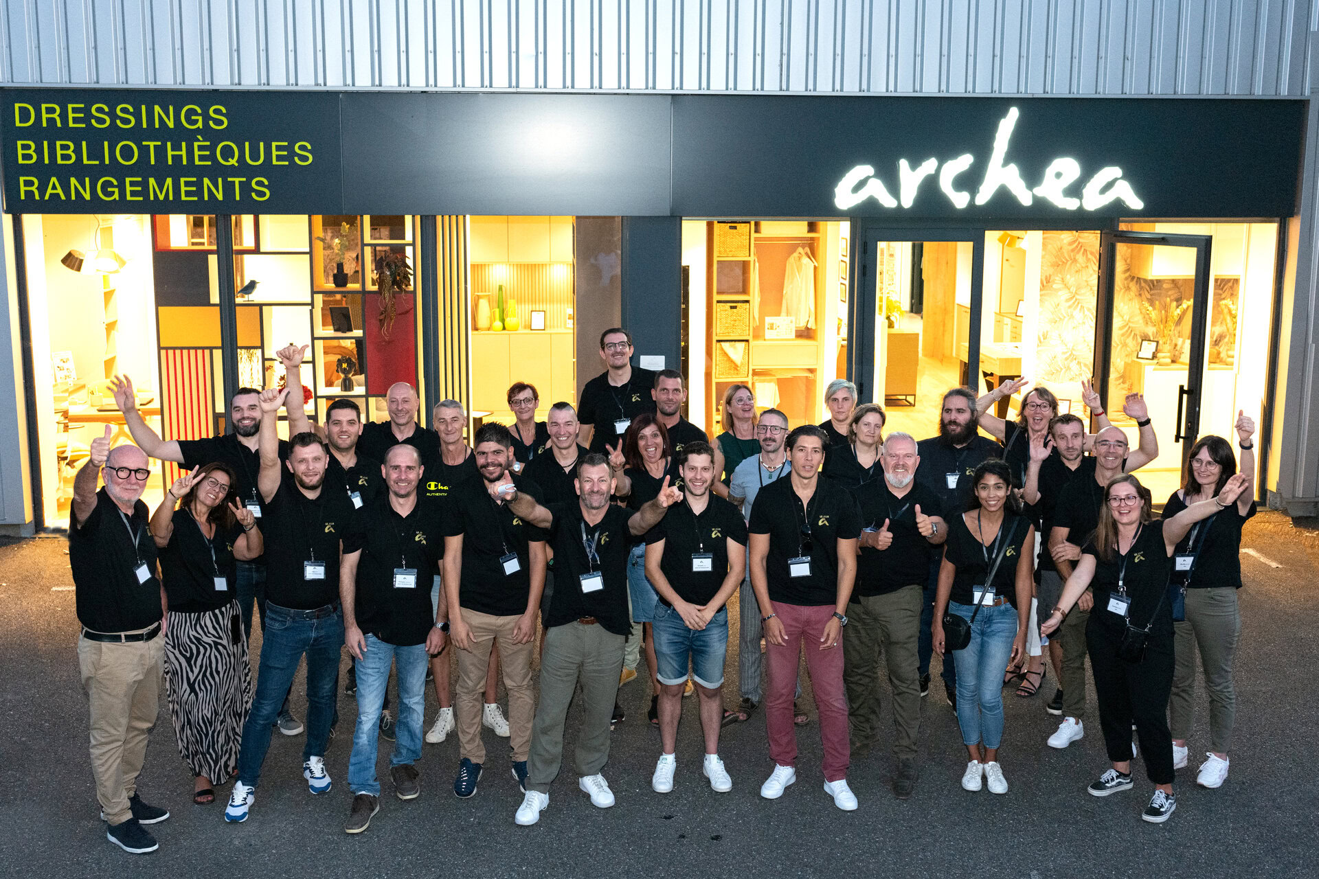 Equipe d'Archea entrain de poser devant un magasin