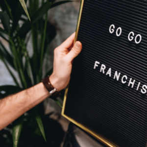 Un tableau noir avec écrit Go go go franchise dessus. Quelqu'un ajoute une lettre au mot.