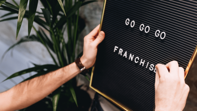 Un tableau noir avec écrit Go go go franchise dessus. Quelqu'un ajoute une lettre au mot.