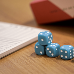 Des dès empilés devant un carnet.