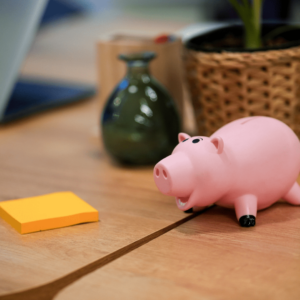 Un cochon tirelire et un bloc de post it jaune.
