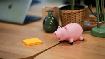 Un cochon tirelire et un bloc de post it jaune.