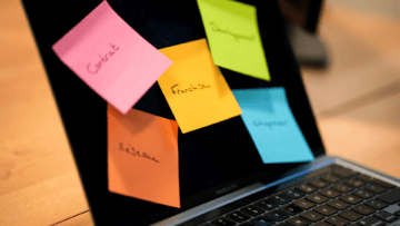 Un post it jaune sur lequel il est noté Franchise est collé sur un écran avec d'autres post it multicolores.