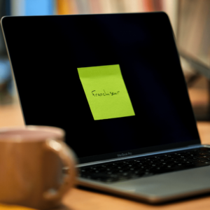 Un ordinateur ouvert avec un post it sur l'écran. Pour illustrer l'idée de devenir franchisé.