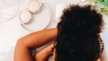Une femme a la tête posée sur ses bras, comme si elle était fatiguée ou désespérée.