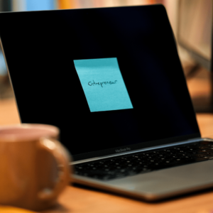 Un post it bleu sur lequel il est écrit Entrepreneur est collé sur un écran d'ordinateur.