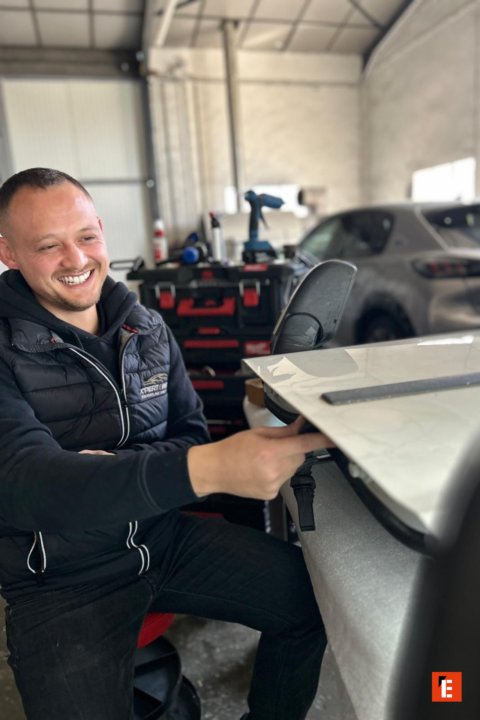 atelier auto : mécanicien retouche un rétroviseur