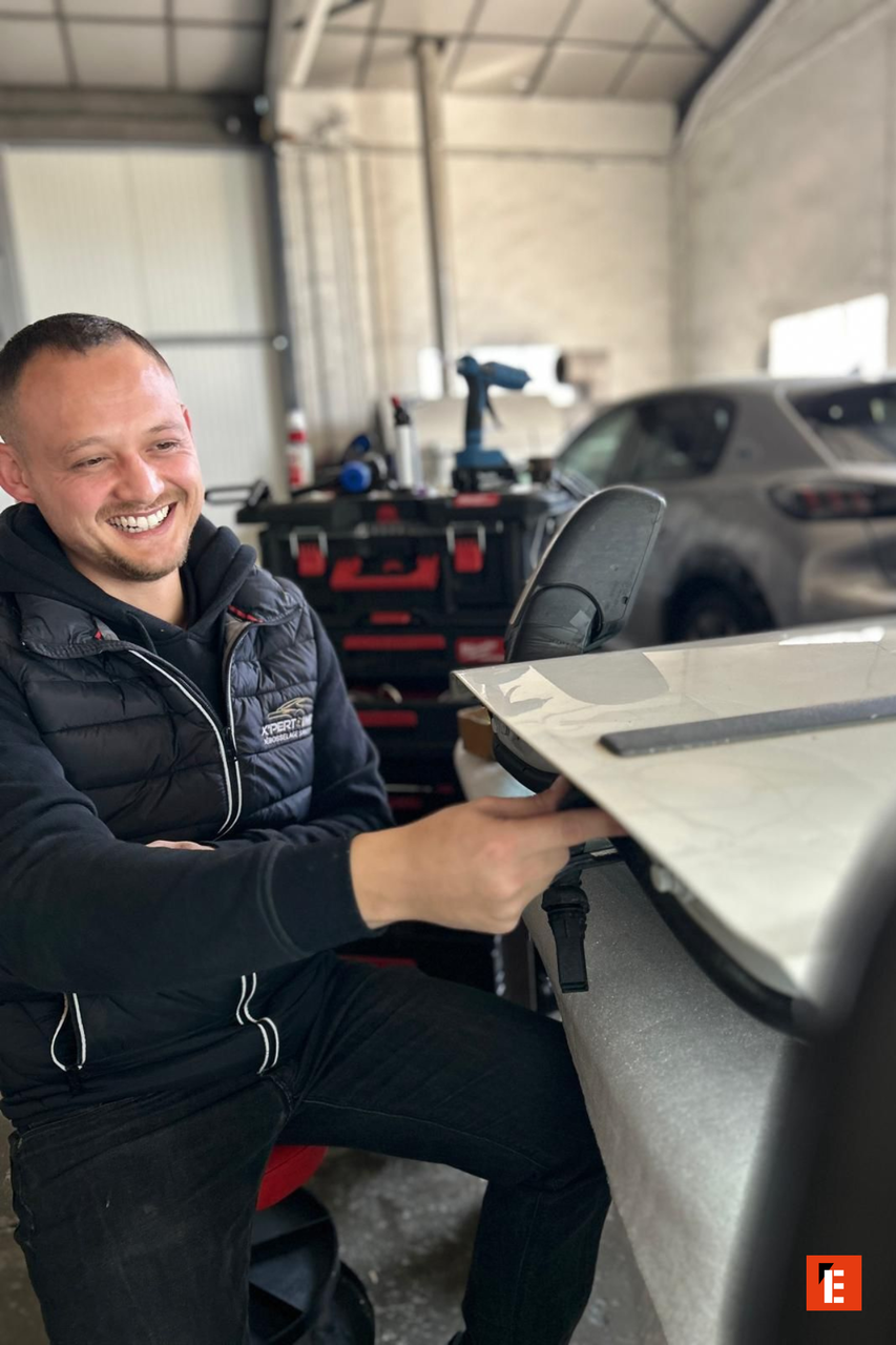 atelier auto : mécanicien retouche un rétroviseur