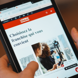 Une tablette sur laquelle figure la home page de L'Express Franchise pour illustrer l'idée de la reconversion en franchise