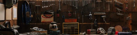 workshop scene. old tools hanging on wall in workshop, tool shelf against a table and wall, vintage garage style