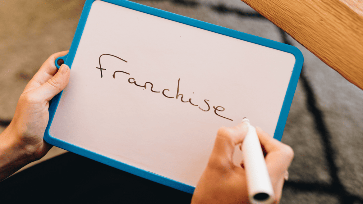 Une ardoise indiquant le mot franchise pour illustrer les conseils pour entreprendre dans la mode.