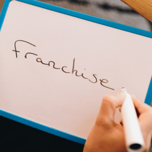 Une ardoise indiquant le mot franchise pour illustrer les conseils pour entreprendre dans la mode.