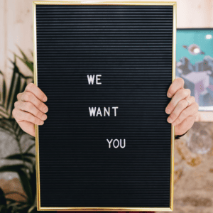 Un panneau noir we want you pour illustrer les différences d'un réseau de franchise.