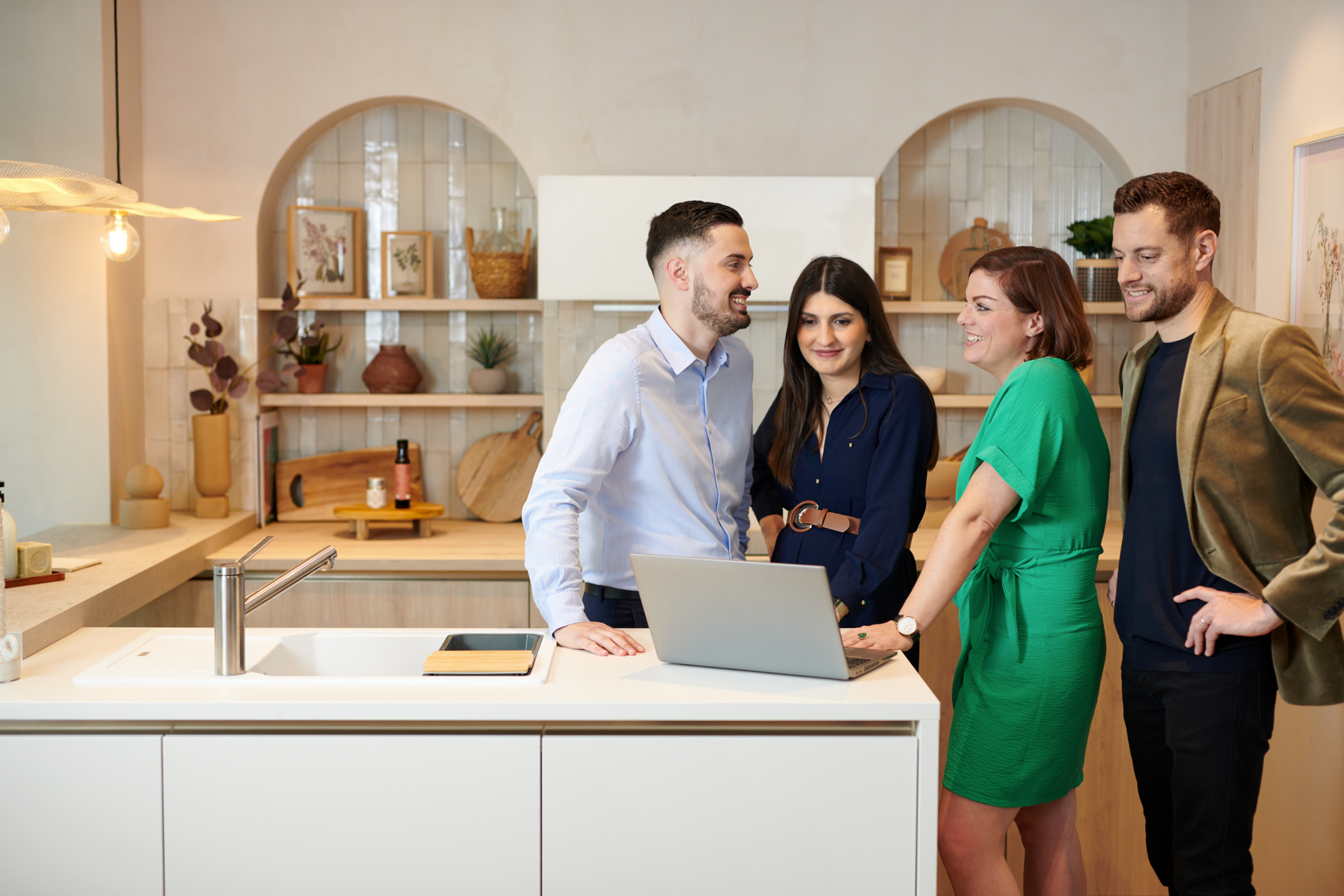un groupe de personnes discutant debout dans une cuisine