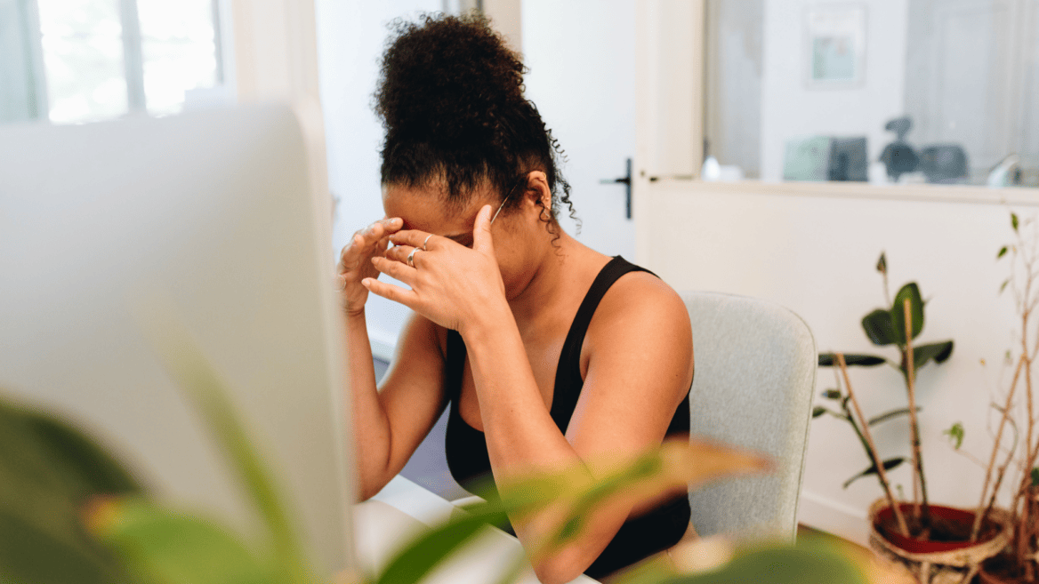 Une personne avec la tête entre les mains pour illustrer l'idée de gérer ses émotions au travail quand on est dirigeant.