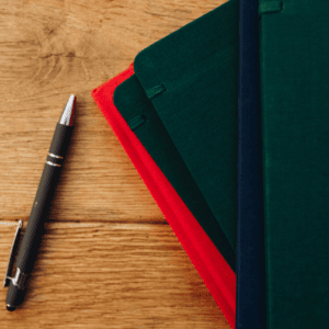 Un stylo et des carnets pour illustrer le contrat de réservation de zone en franchise.