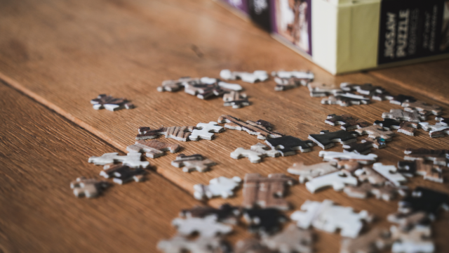 Des pièces de puzzles éparpillées sur une table en bois.