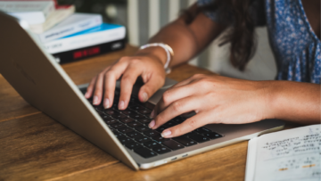 Une internaute utilise son ordinateur, on ne voit que ses mains.
