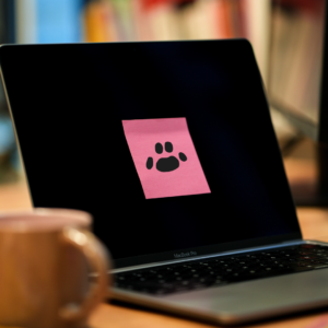 Un post it rose est collé sur un écran d'ordinateur, il y est dessiné une empreinte d'animal.