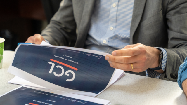 Une présentation de GCL experts gestion feuilletée par un homme en costume.