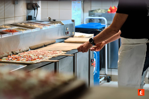 préparation de pizzas sur ligne en cuisine pro