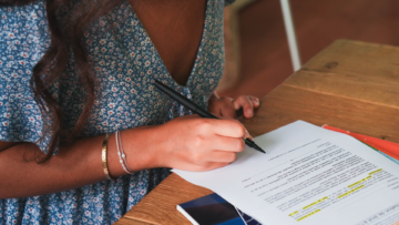 Une jeune femme signe un contrat.