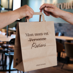 Dans un restaurant class'croute, deux personnes échange un sac en papier.