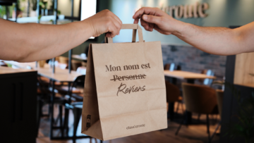 Dans un restaurant class'croute, deux personnes échange un sac en papier.
