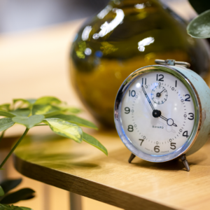 Un réveil matin posé sur une table en bois indique 3h55.
