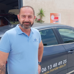Grégory Boucquez, franchisé Horde d'Or devant sa voiture de fonction.