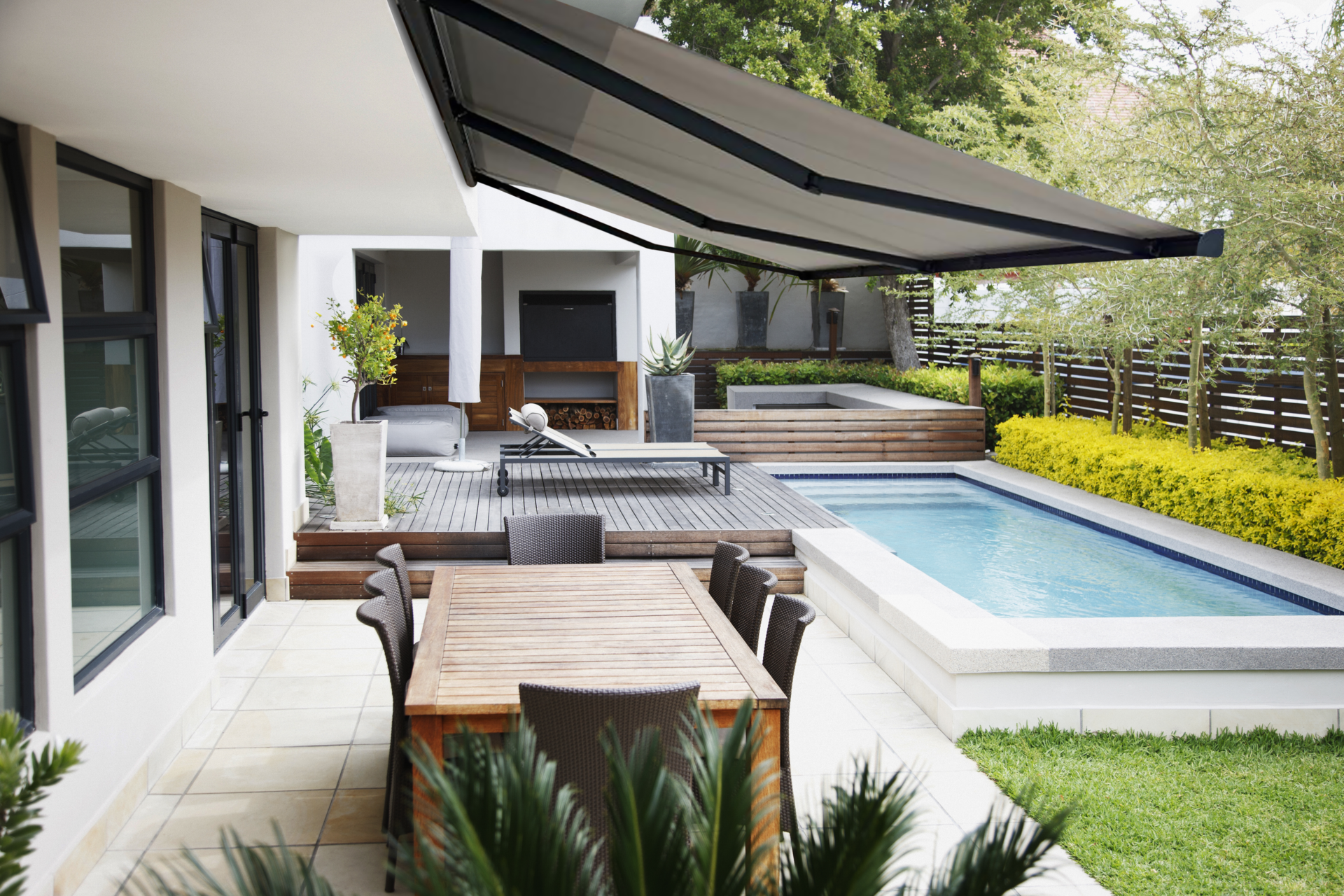 Store abritant une terrasse avec une piscine