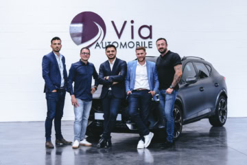 Equipe de la franchise Via Automobile posant sur une voiture