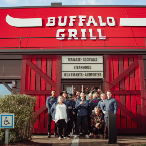 Equipe posant devant un restaurant Buffalo Grill